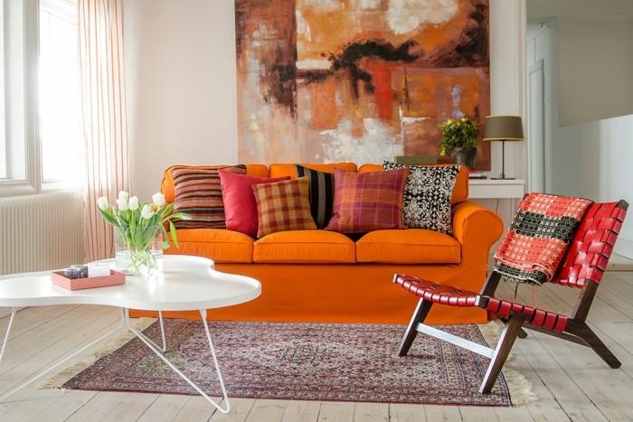 seinämaalaukset olohuone oranssi sohva heittää tyynyt matto puulattia