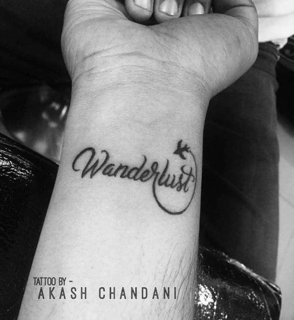 Wanderlust tatuointi motiivi kirjain ranne