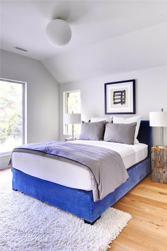 valkoinen makuuhuone sininen sänky valkoiset seinät matto maalaismainen sivupöydät