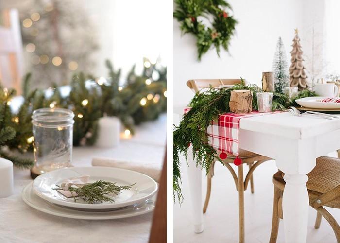 joulupöydän koristelu paljon vihreitä kuusen oksia valkoinen pöytäliina