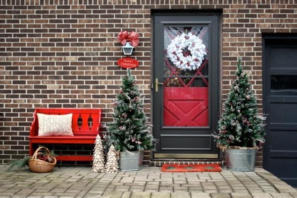 joulukoristeita talon sisäänkäynti valkoinen joulu seppele kuuset punaiset aksentit