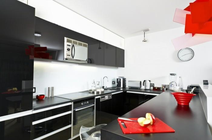 moderni musta ja valkoinen keittiö, jossa punaiset aksentit ja u -muoto
