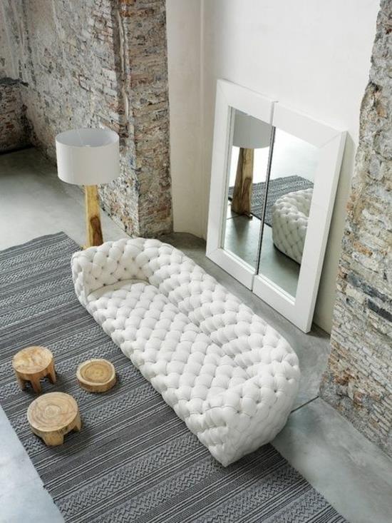olohuoneen sisustus suunnittelija sohva peili puu kivi kontrasti