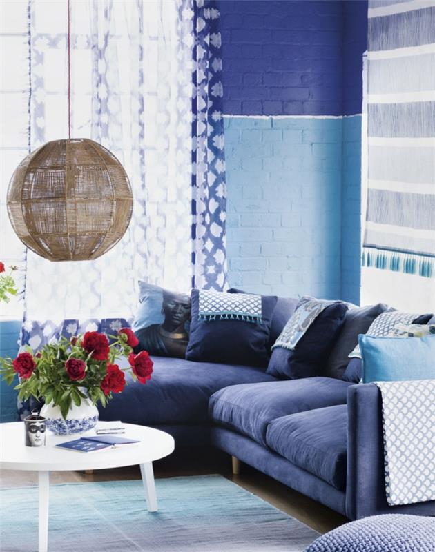 olohuoneen sohva sininen pyöreä pöytä kukat riippuvalaisin
