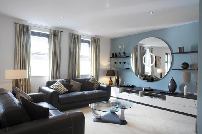 olohuone design sininen aksentti seinä pyöreä seinäpeili musta nahka sohvat