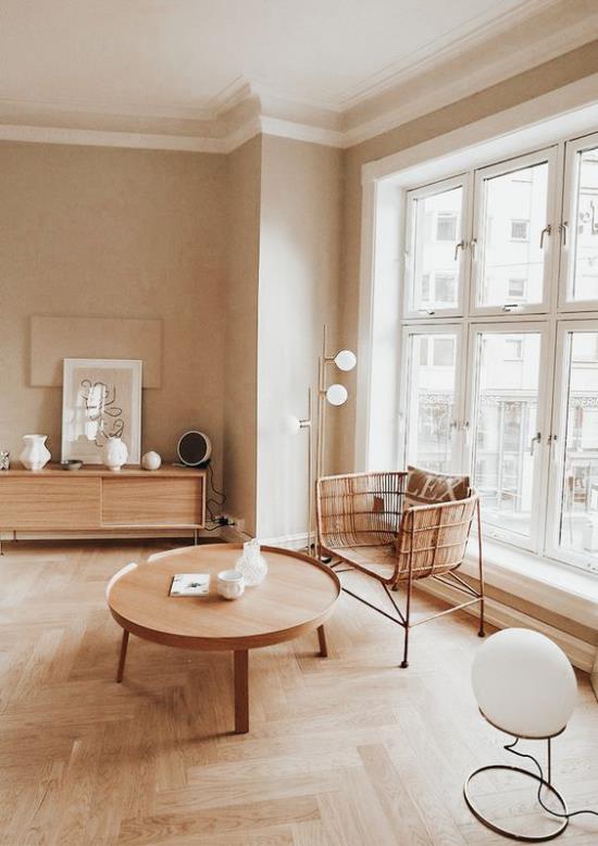 ajattomat värit yksinkertaisesti sisustettu olohuone valkoinen beige ja paljon puulattiat parkettilattia paju nojatuoli pyöreä matala puinen pöytä