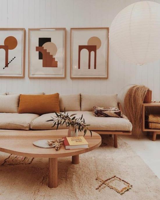 ajattomat värit viihtyisä olohuone lämpimissä maanläheisissä vivahteissa valkoinen beige poltettu siena -sohva matto seinäkoriste pyöreä matala puinen pöytä